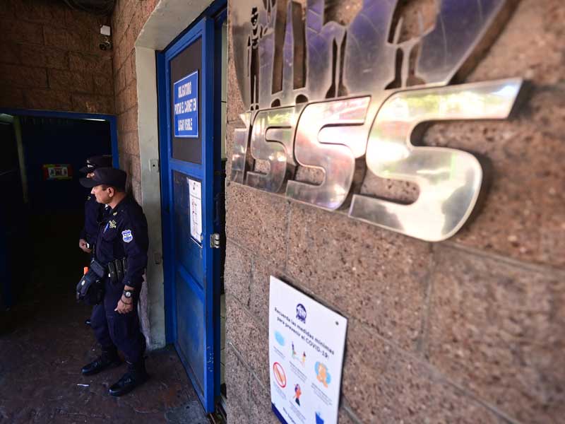 Agentes de la PNC sustituyen a vigilantes privados en un intento de las autoridades de supuestamente reducir costos en el Seguro Social (ISSS). Crisis en el seguro social.