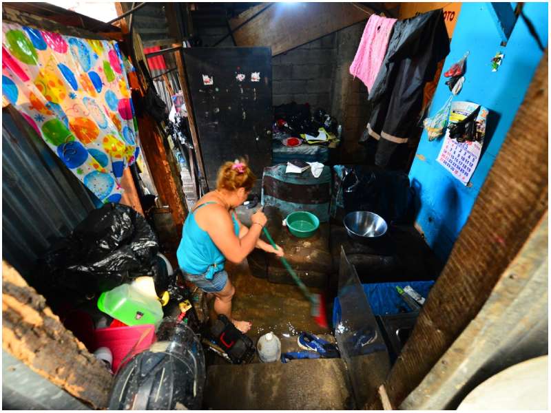 Una mujer saca el lodo tras la inundación de su casa. Foto / Lissette Monterrosa