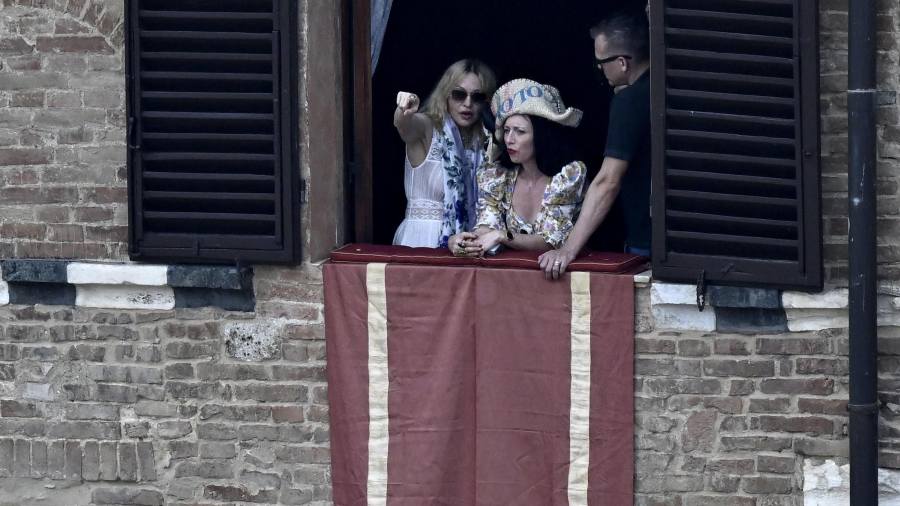 La cantante Madonna (i) asiste a la histórica carrera de caballos italiana Palio di Siena desde el Palazzo Pannocchieschi d'Elci en la Piazza del Campo en Siena, Italia, el 16 de agosto de 2025. Foto: EFE