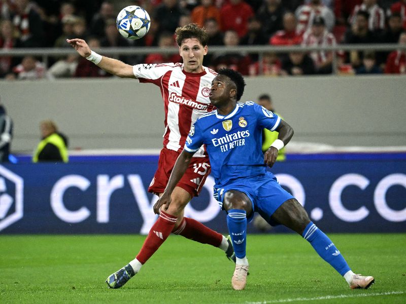 El defensa Panagiotis Retsos (i.) disputa el balón col el delantero brasileño Vinicius Junior (d.), en el duelo del Real Madrid ante el Olympiakos, Foto: EDH AFP