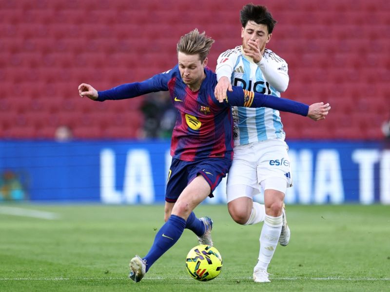 El centrocampista del Barcelona, ​​Frenkie De Jong (i.), disputa el balón ante Alberto Reina, del Real Oviedo, en el Camp Nou. Foto: EDH AFP