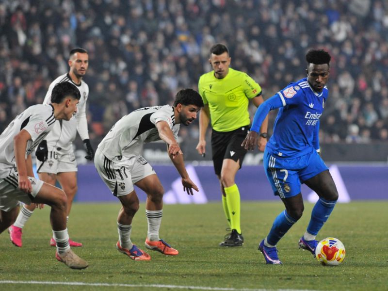 El centrocampista del Albacete, Ale Meléndez (c), busca el balón ante el delantero del Real Madrid, Vinícius Jr (d.), por octavos de la Copa del Rey. Foto: EDH AFP