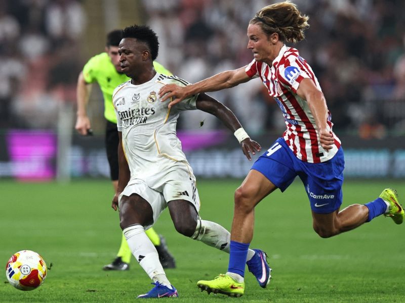 El delantero brasileño del Real Madrid, Vinícius Junior, recibe un balón ante la marca de un rival del Atlético de Madrid, durante la semifinal de la Supercopa de España. Foto: EDH AFP