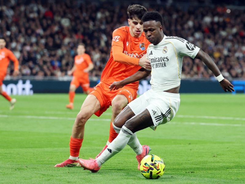 El defensa de la Real Sociedad, Jon Martin (i.), y el delantero brasileño del Real Madrid, Vinicius Junior (d.), luchan por el balón durante el partido entre el Real Madrid y la Real Sociedad, en el estadio Santiago Bernabéu. Foto: EDH AFP