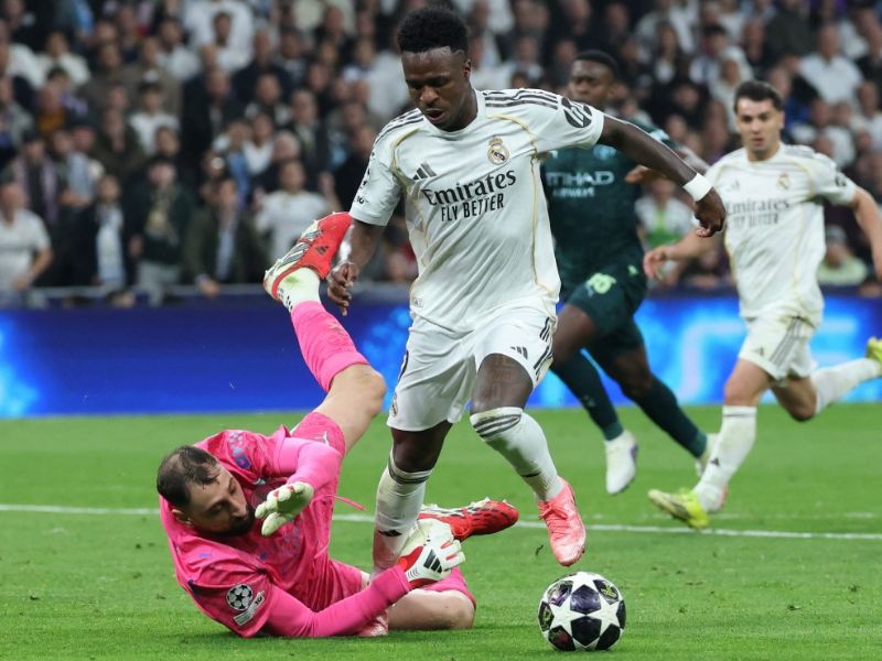 El delantero brasileño del Real Madrid, Vinicius Junior (d.), recibe una falta del portero italiano del Manchester City, Gianluigi Donnarumma, en la ida de octavos de la Champions. Foto: EDH AFP