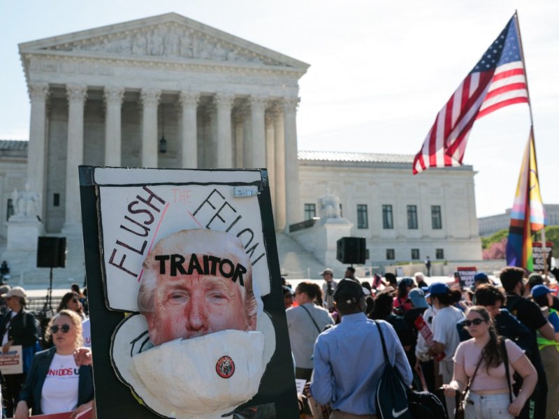 Un cartel anti-Trump se exhibe mientras manifestantes se congregan frente a la Corte Suprema de Estados Unidos, donde el presidente Donald Trump asiste a las audiencias orales en Washington, D.C., el 1 de abril de 2026. Foto EDH/AFP