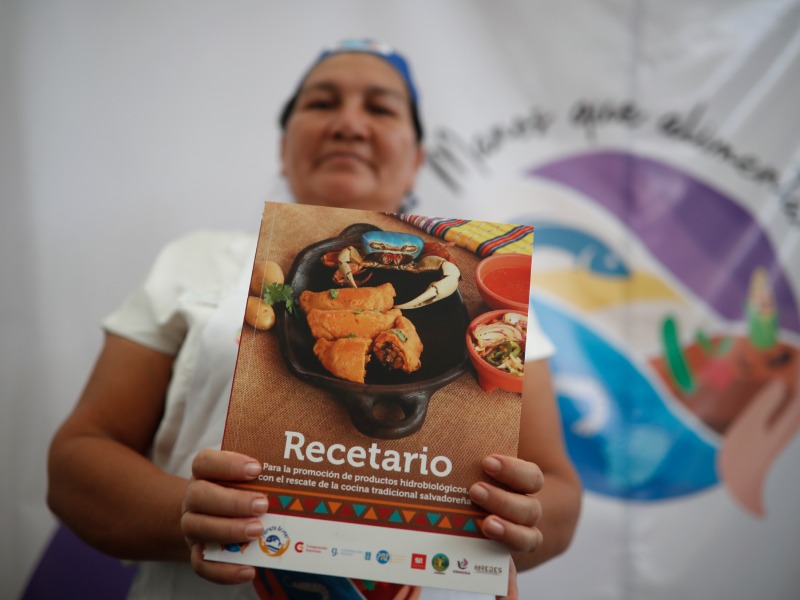 Una mujer sostiene un recetario del proyecto de seguridad alimentaria Manos que Alimentan este 28 de abril de 2026, en San Salvador (El Salvador). EFE/ Rodrigo Sura