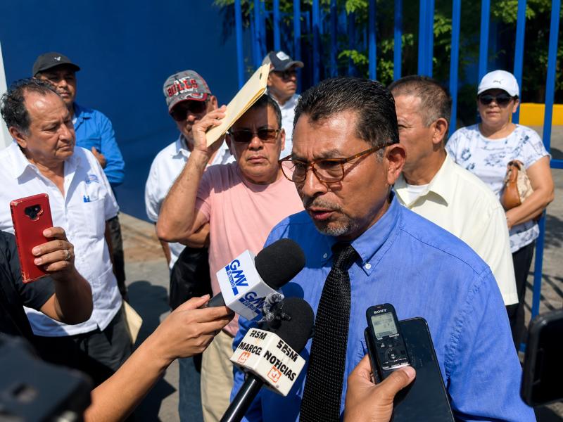 Representante magisterial brinda declaraciones a medios durante concentración frente al Ministerio