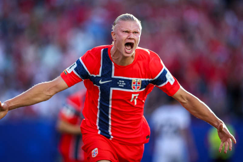 Erling Haaland con el uniforme de Noruega celebrando con un salto tras anotar el primer gol frente a Irak.