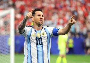 Lionel Messi con la camiseta de Argentina celebrando con los brazos abiertos tras anotar un gol contra Austria en el Dallas Stadium.