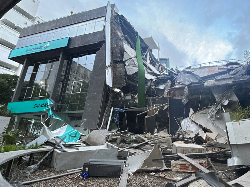Fachada destruida y escombros de una sucursal del banco Bancaribe en Caracas, mostrando los daños estructurales severos causados en la edificación por el fuerte sismo.