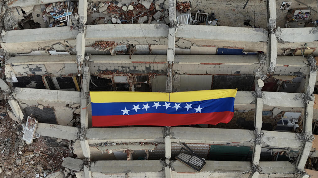 Una gran bandera de Venezuela cuelga de un edificio destruido por los terremotos del 24 de junio al norte del país, una imagen tomada el 20 de julio de 2026 en Caraballeda, en el estado de La Guaira