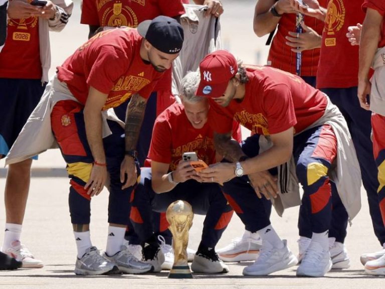 El delantero Daniel Olmo y el portero David Raya posan sonrientes con su trofeo en la pista de aterrizaje del aeropuerto de Madrid Barajas, tras regresar de Estados Unidos como campeones del Mundial de 2026.