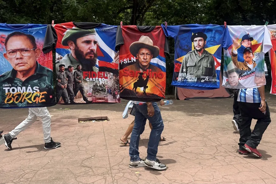 Personas caminan detrás de camisetas estampadas con la imagen de varios líderes políticos de la izquierda latinoamericana durante la celebración del 47 aniversario de la revolución que derrocó por la vía armada a la dictadura de Anastasio Somoza Debayle, este domingo, en Managua (Nicaragua). EFE