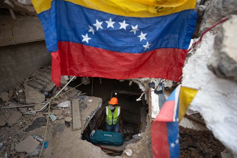 Una persona realiza labores de búsqueda entre los escombros de edificios destruidos por terremotos en La Guaira (Venezuela). EFE/
