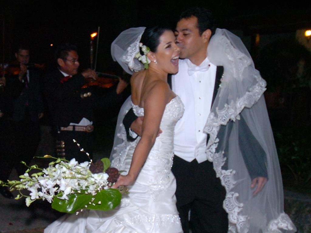 Juan Carlos Alarcón besando a Verónica Guerrero rodeados de mariachis durante la fiesta de bodas.