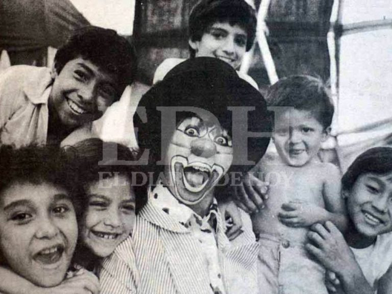 SONRISAS INFANTILES. Un payaso caracterizado se toma una entrañable fotografía rodeado de niños sonrientes, reflejando el ambiente de júbilo y diversión familiar que caracteriza los festejos. Foto EL DIARIO DE HOY / Archivo