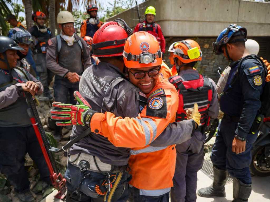 Un emotivo abrazo de solidaridad entre un miembro de Protección Civil de El Salvador y un paramédico vial en la zona de operaciones.