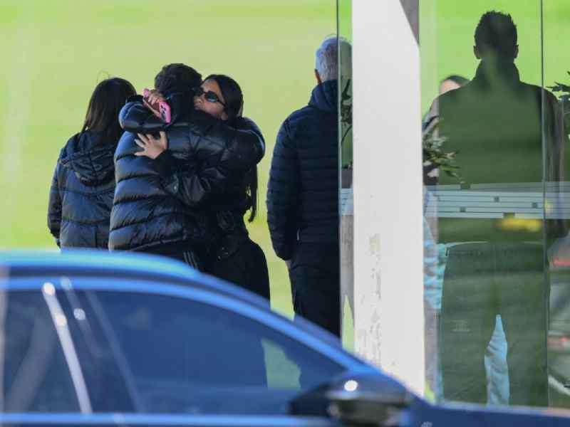 Antonela Roccuzzo ofrece un abrazo de condolencia a un familiar durante las honras fúnebres de Jorge Messi.