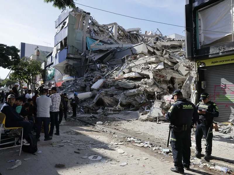 Integrantes de la Policía Nacional de Colombia y civiles en frente de una edificación destruida tras el terremoto de magnitud 7,4 que sacudió este lunes a varias zonas de Colombia, Pereira (Colombia). Foto EDH-EFE