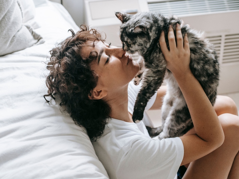 Joven hace cariñito a su gato