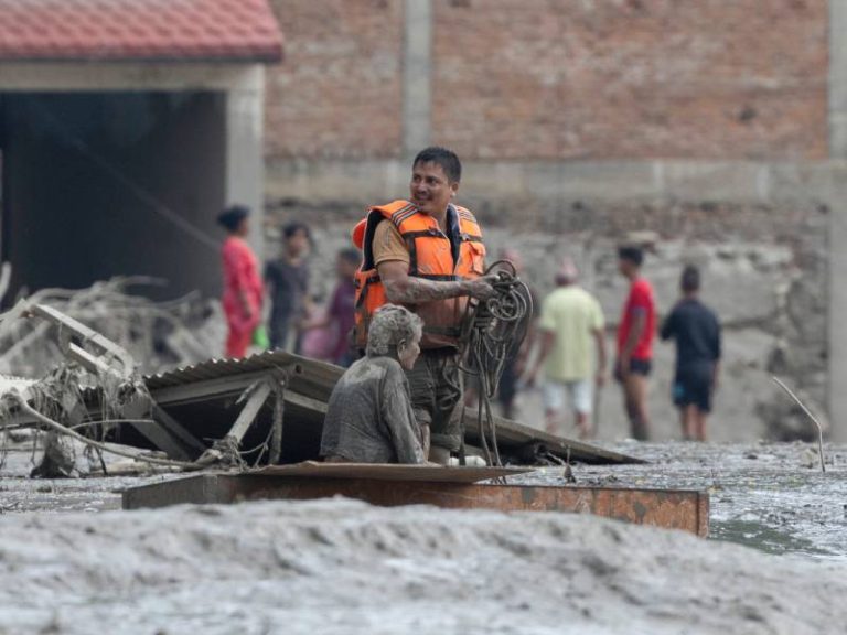 Equipos de emergencia trasladas a una mujer de la tercera edad rescatada tras desbordamiento e inundación en Nuwakot, Nepal.