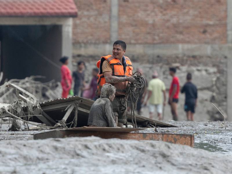 Equipos de emergencia trasladas a una mujer de la tercera edad rescatada tras desbordamiento e inundación en Nuwakot, Nepal.