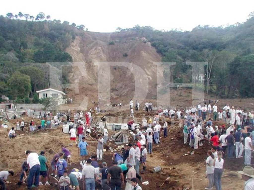 Multitud de voluntarios y rescatistas excavando en las laderas del colapso en Las Colinas con la casa Guirola al fondo.