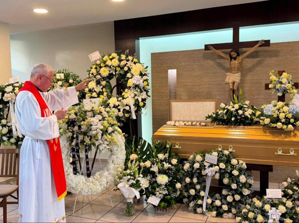 El padre Juan Vicente Chopín bendice el ataúd con los restos de Andrés Espinoza.