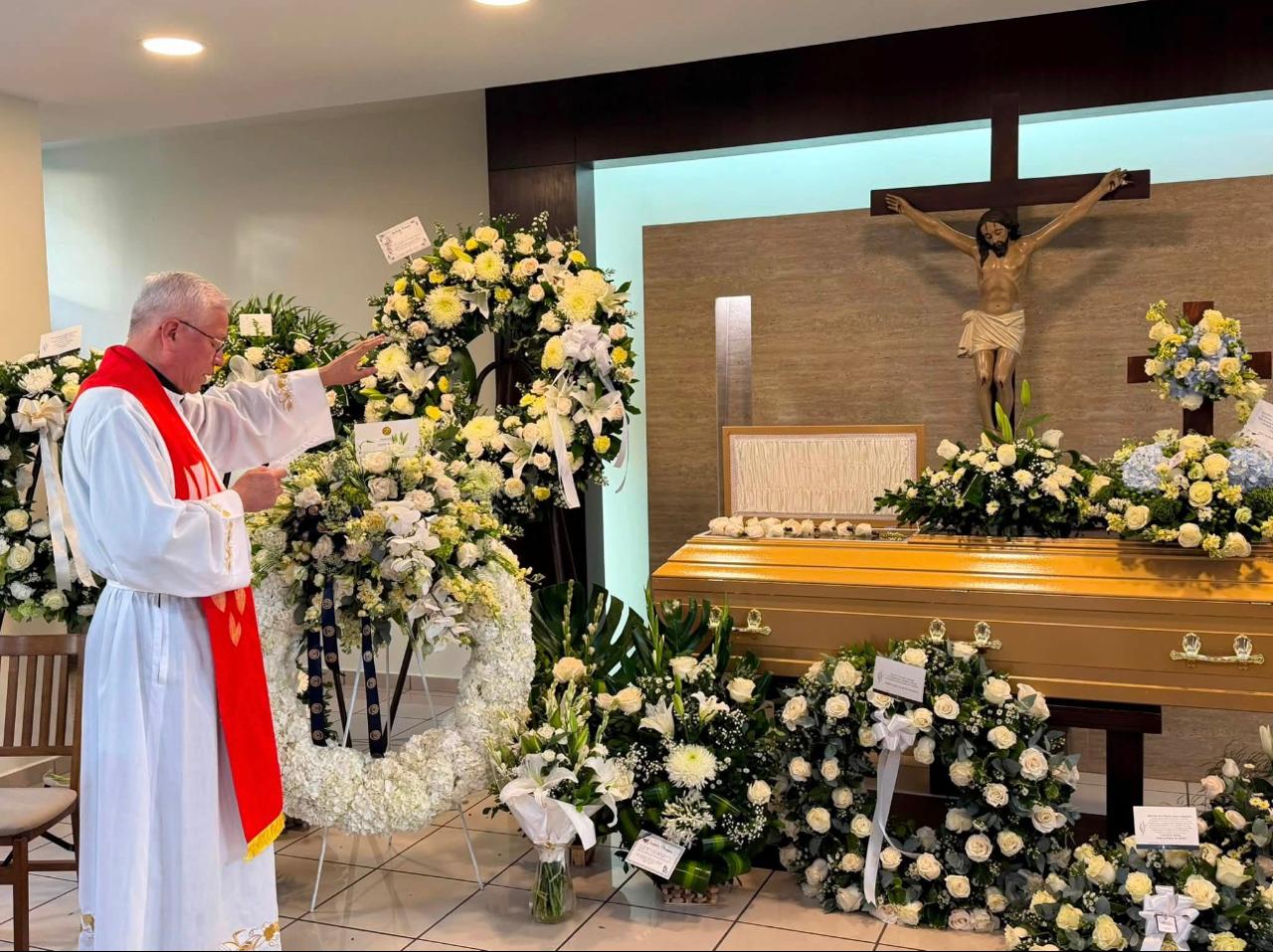 El padre Juan Vicente Chopín bendice el ataúd con los restos de Andrés Espinoza.