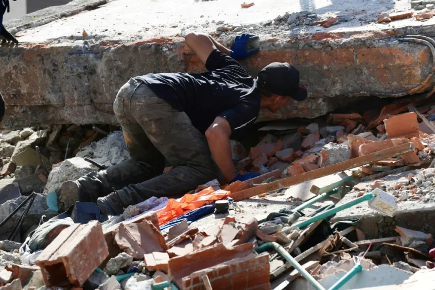 Un hombre de 35 años trabaja sin descanso sobre una pequeña montaña de escombros pero ha perdido la esperanza de encontrar con vida a la mujer que considera como una madre