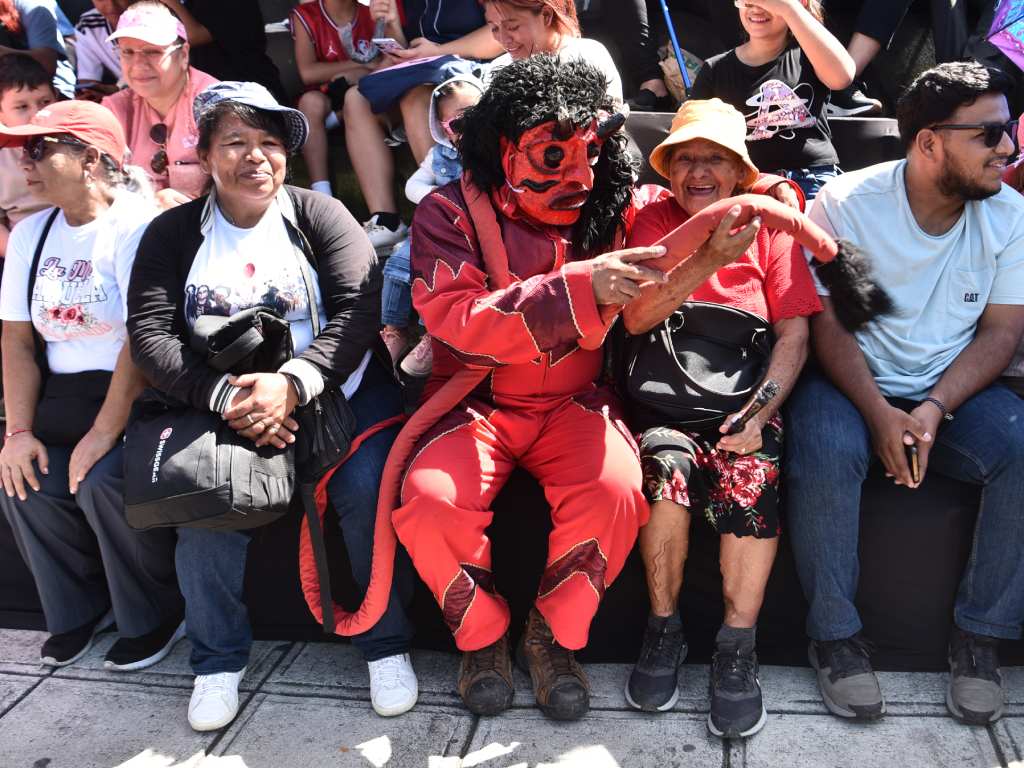 Algunos de los asistententes al desfile le siguen la corriente a los Viejos de Agosto con el fin de pasar un momento de diversión.