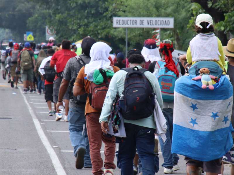 Grupo de aproximadamente 300 personas migrantes mayoritariamente hondureñas cruzando la frontera de Guatemala a México.