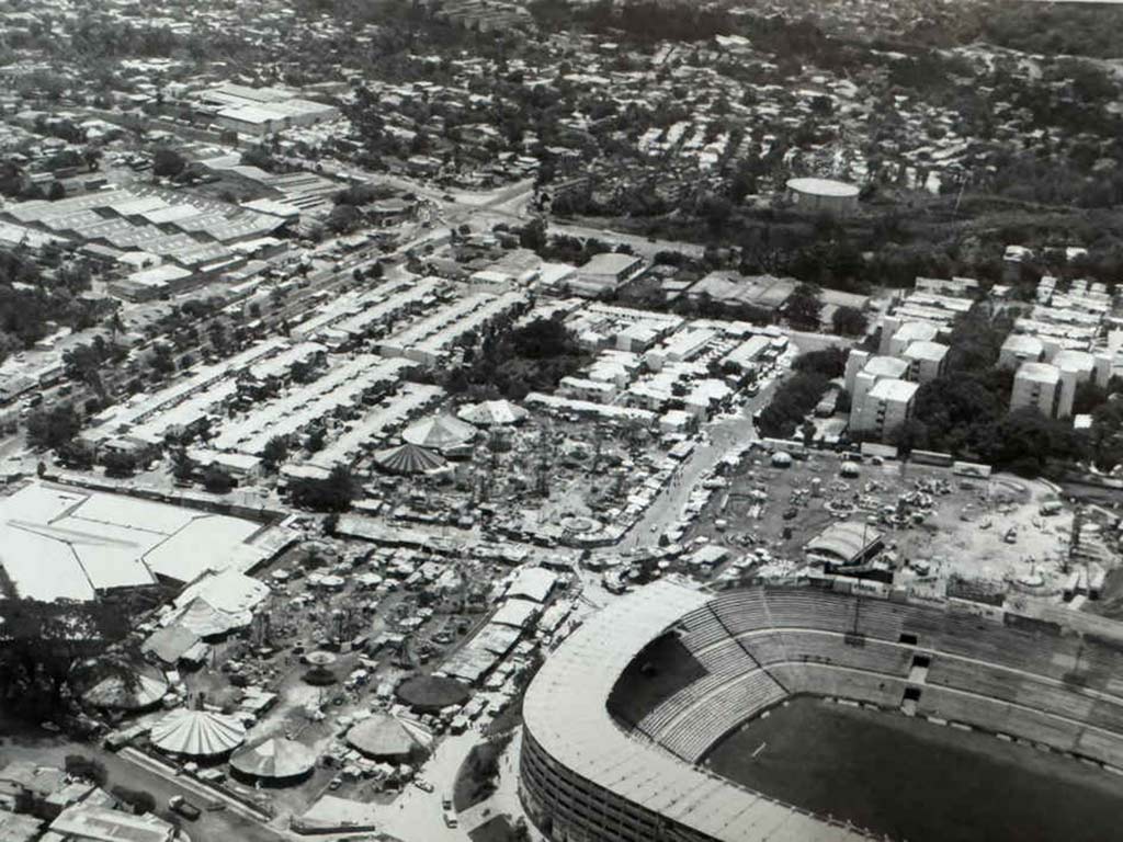 Fotografía aérea antigua del Estadio Cuscatlán en San Salvador con las atracciones mecánicas del campo de la feria al lado.