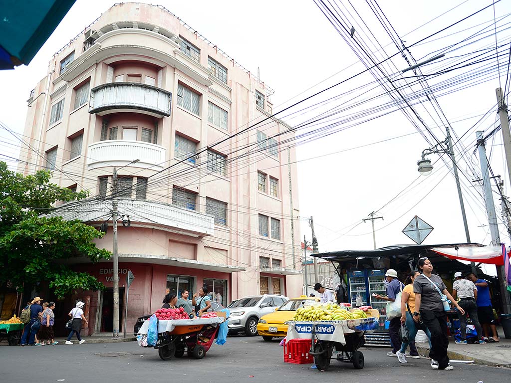 Edificio historico V y R y vendedores con carretillas de frutas en calle arce
