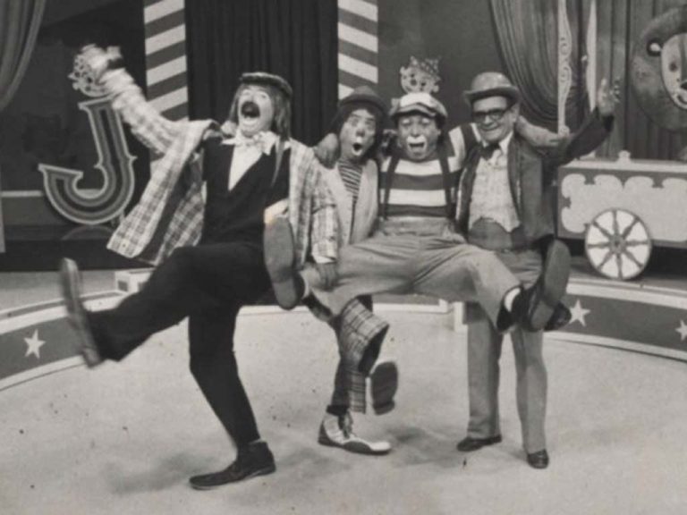 Foto antigua en blanco y negro del elenco de payasos y Tío Periquito en Jardín Infantil.