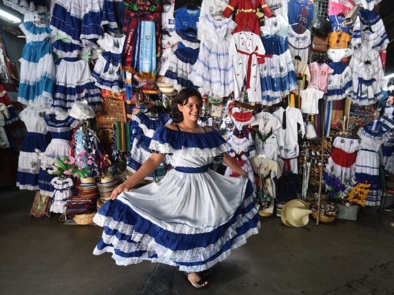 Con una sonrisa, una joven luce la belleza del traje típico salvadoreño en el Mercado Excuartel.