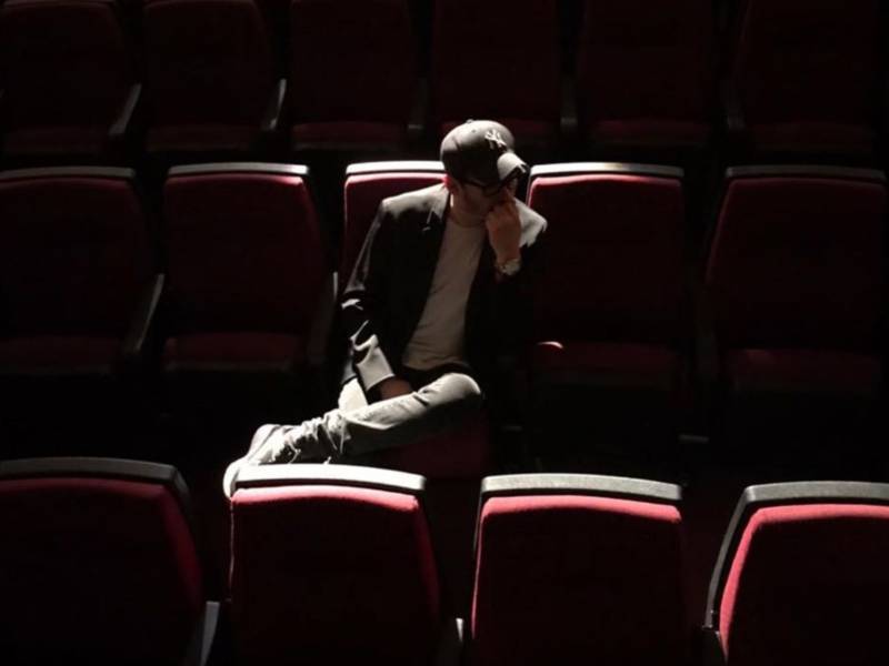 Alex Oviedo en las butacas de una sala de cine, con las luces apagadas
