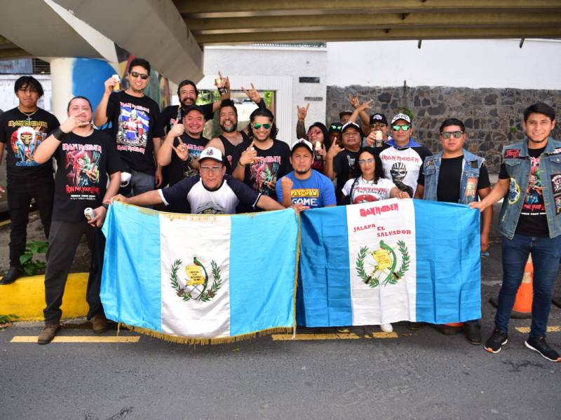Seguidores de Iron Maiden procedentes de Guatemala posan sosteniendo una bandera de su país.