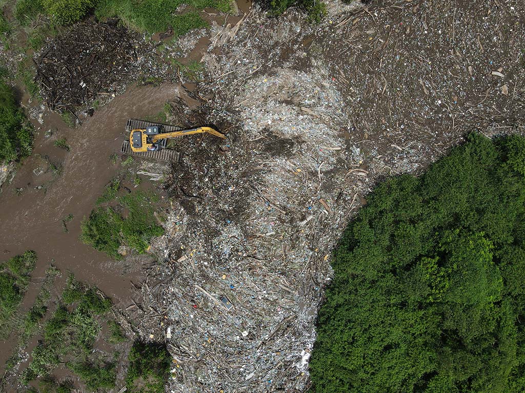 Pala pantanera anfibia del Ministerio de Obras Públicas realizando trabajos de extracción de desechos sólidos en el río Grande de San Miguel.