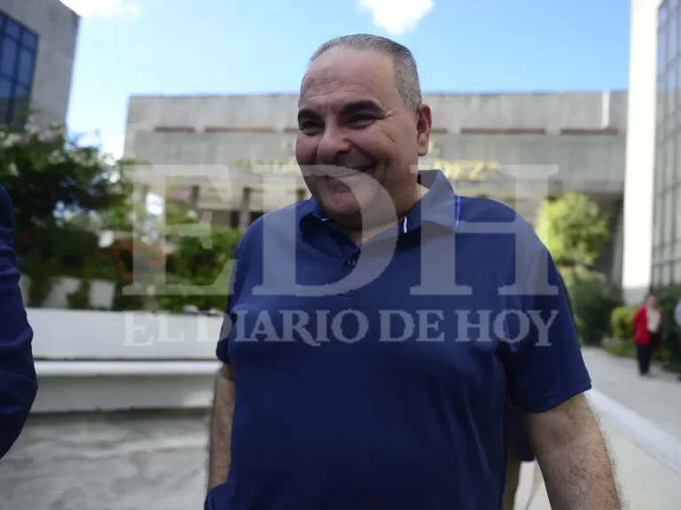 Antonio Saca gesticulando con la mano abierta mientras camina hacia la salida del recinto judicial