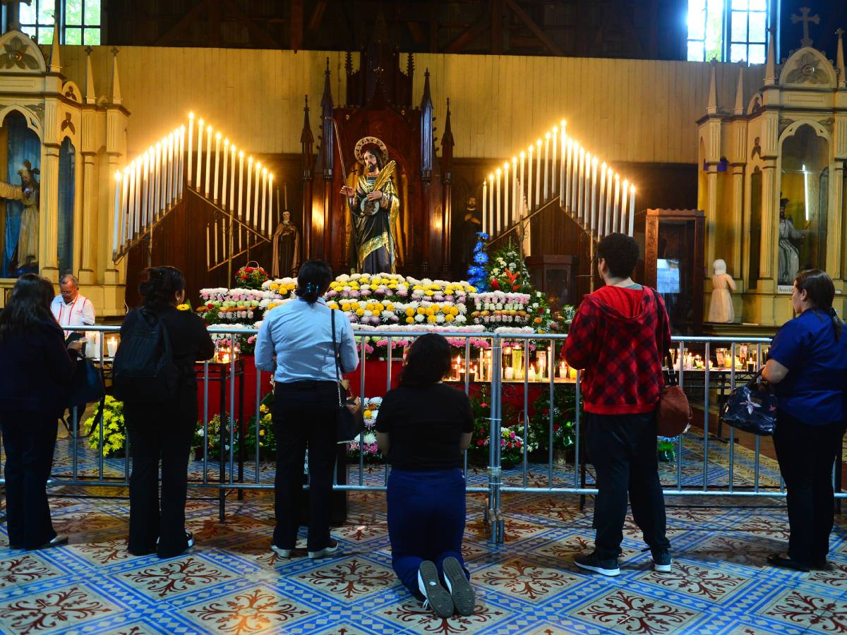 Feligrés en un templo religioso vistiendo un escapulario franciscano sobre su espalda.