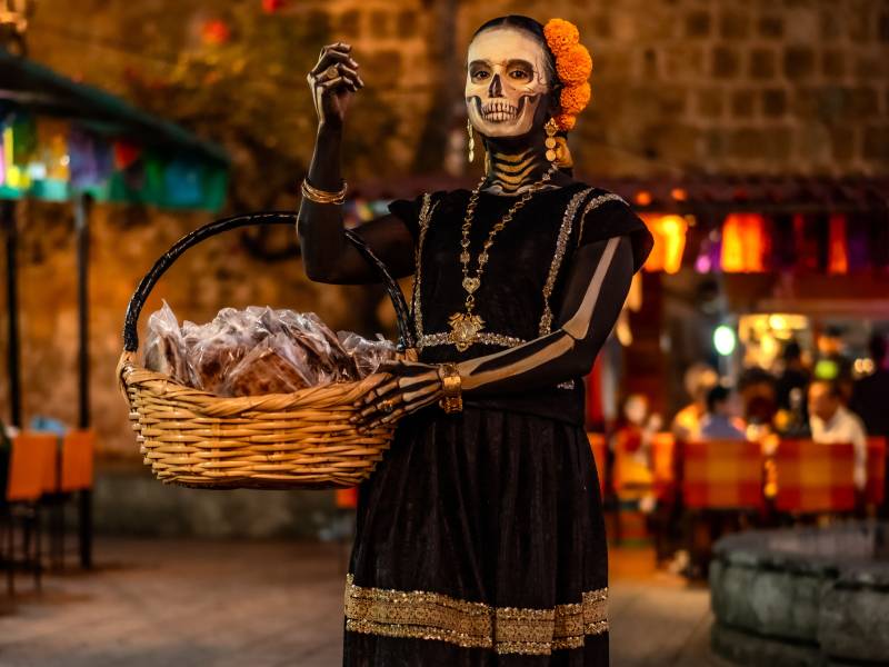 Mujer caracterizada de Catrina en una cocina tradicional mexicana