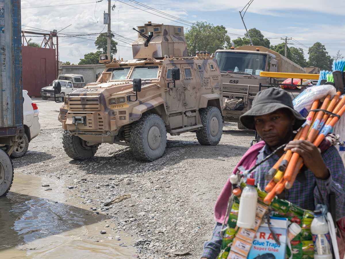 Vendedor de artículos para el hogar en Puerto Príncipe frente a un blindado de combate de las tropas aliadas de la ONU